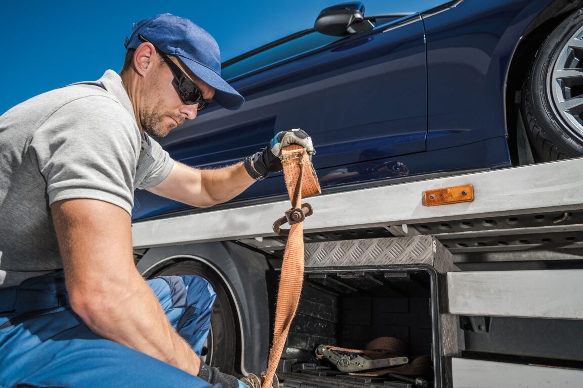 Tow truck driver securing a vehicles